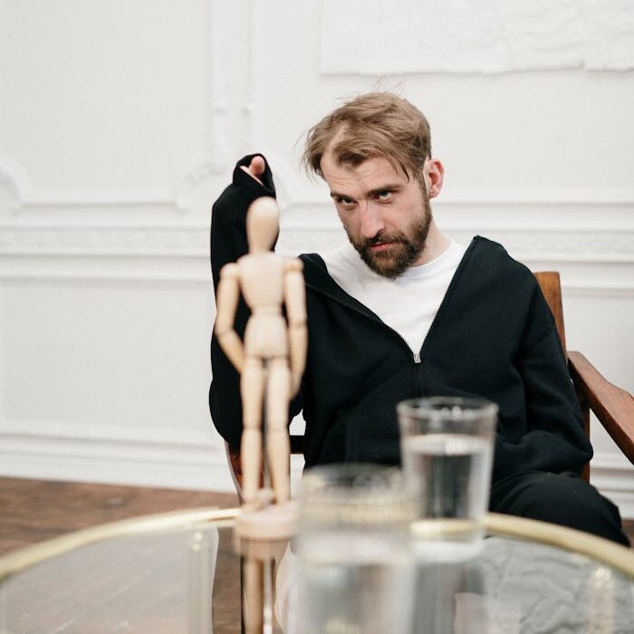 Man in Black Suit Sitting on Brown Wooden Chair